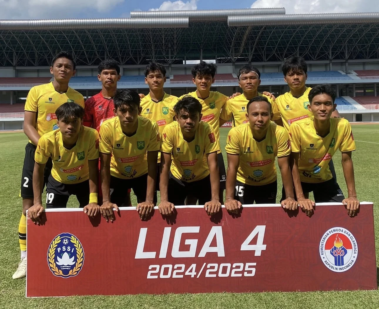 Skuad Gabsis Sambas berkit kandang kuning NOIR berbaris di belakang spanduk Liga 4 2024/2025